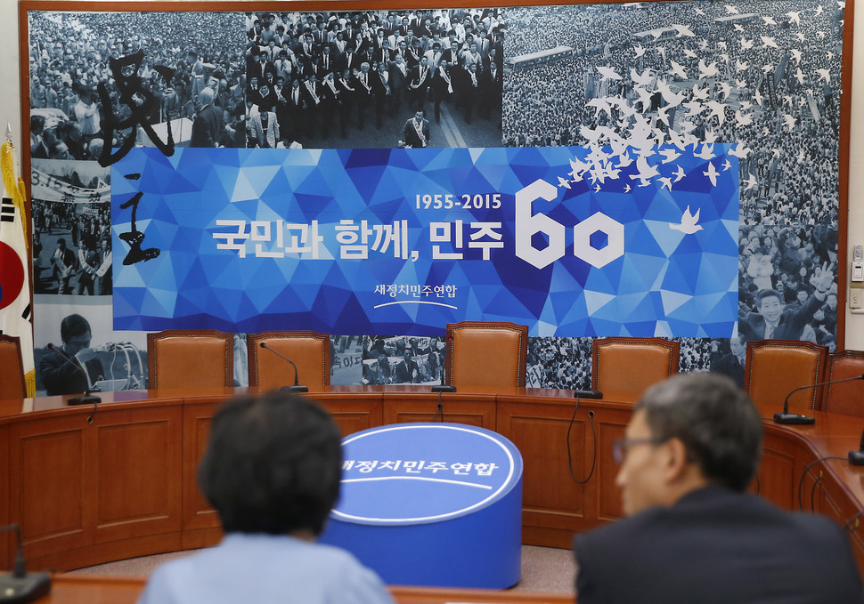 창당 60주년을 기념하는 ‘국민과 함께, 민주60년‘ 현수막이 9일 국회 새정치민주연합 당 대표회의실에 걸려 있다. 현수막 상단에는 행진하는 김영삼 전 대통령, 왼쪽 하단에는 눈물을 닦는 김대중 전 대통령, 오른쪽 하단엔 환호에 답하는 노무현 전 대통령의 사진이 실려있다. 연합뉴스