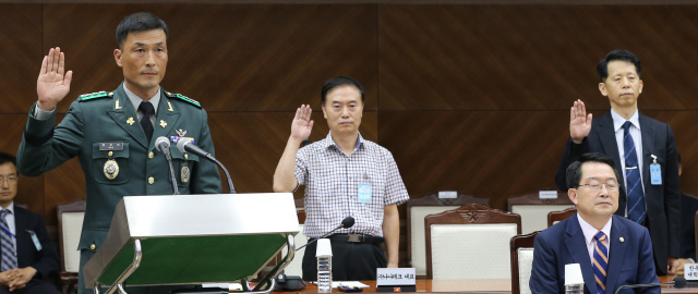 10일 오후 서울 용산구 국방부 대회의실에서 열린 국회 국방위원회의 국방부 국정감사에서 국가정보원의 해킹 프로그램 구입과 관련해 일반 증인으로 출석한 허장안 육군 대령, 허손구 나나테크 대표, 한희 한독미디어대학원대학교 교수(왼쪽부터)가 증인 선서를 하고 있다. 앉은 이는 백승주 국방부 차관이다. 이종근 기자 <A href="mailto:root2@hani.co.kr">root2@hani.co.kr</A>