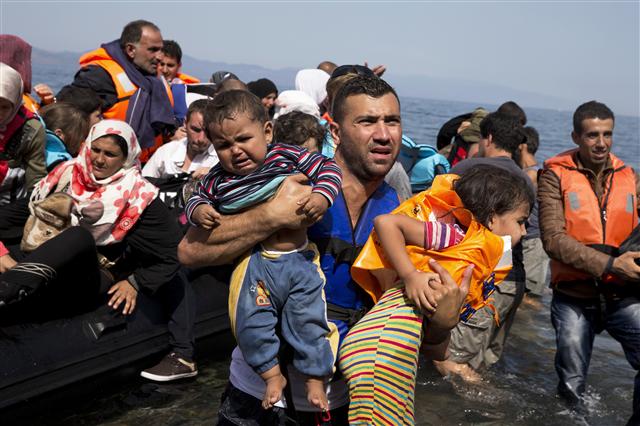 지난 10일 터키에서 소형보트를 타고 그리스의 레스보스섬에 도착하는 시리아 난민들. 난민 유입은 유럽 경제에 도움을 줄 수도 있다.  레스보스/AP 연합뉴스