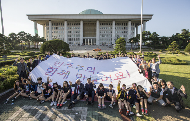 세계 민주주의의 날을 맞아 민주화운동기념사업회가 15일 오후 국회 잔디광장에서 연 기념행사에서 우다야 라이 이주노동자 노동조합 위원장, 콩고 출신 난민인 욤비 토나 광주대 교수 등 참가자들이 ‘민주주의, 함께 만들어요’라고 쓴 대형 펼침막을 들어 보이고 있다. ‘세계 민주주의의 날’은 유엔이 반기문 사무총장 취임 첫해인 2007년에 정했다. 김성광 기자 flysg2@hani.co.kr