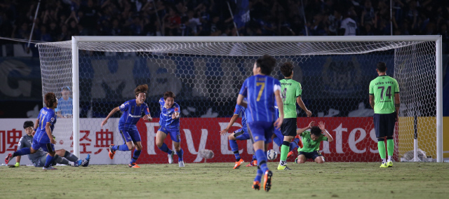 감바 오사카 선수들이 16일 일본 오사카 엑스포70 스타디움에서 열린 2015 아시아축구연맹(AFC) 챔피언스리그 8강 최종 2차전에서 후반 3분 추가시간에 결승골을 넣은 뒤 기뻐하고 있다. 전북 현대 선수들은 뜻밖의 일격에 망연자실하는 모습. 스이타/김정효 기자 hyopd@hani.co.kr