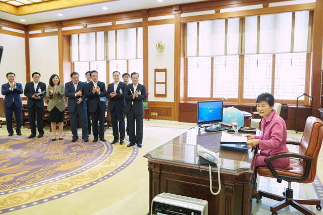 박근혜 대통령이 21일 오전 청와대에서 청년희망펀드 공익신탁 가입신청서에 서명을 마치자 수석비서관들이 박수를 치고 있다.  청와대 제공