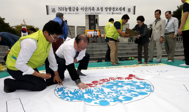 엔에이치(NH)농협금융이 추석을 앞두고 이산가족을 초청해 23일 오전 경기 파주 임진각 망배단에서 연 망향경모대제 참석자들이 제사를 마친 뒤 통일을 기원하며 태극기에 손도장을 찍고 있다.  
 파주/김경호 선임기자 jijae@hani.co.kr 