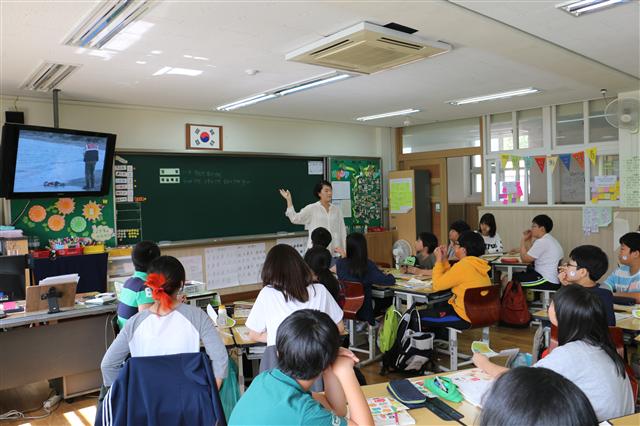 지난달 24일 서울 발산초에서 인권친화교실을 운영하는 이은진 교사가 학생들과 각국의 인권침해 사례를 알아보는 수업을 진행하고 있다.  국제앰네스티 제공