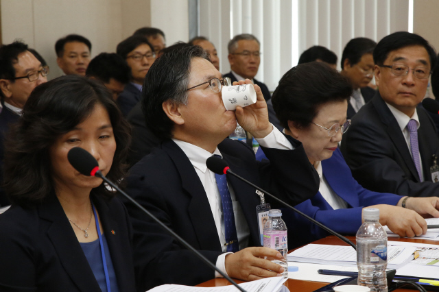 김호섭 동북아역사재단 이사장(왼쪽)이 5일 오전 국회에서 열린 교육문화체육관광위원회 국정감사에서 2013년 자신이 ‘역사왜곡과 학문탄압을 걱정하는 지식인 모임’의 일원으로 서명한 성명서의 내용을 질타하는 야당 의원들의 발언을 들으며 물을 마시고 있다. 이정아 기자 leej@hani.co.kr