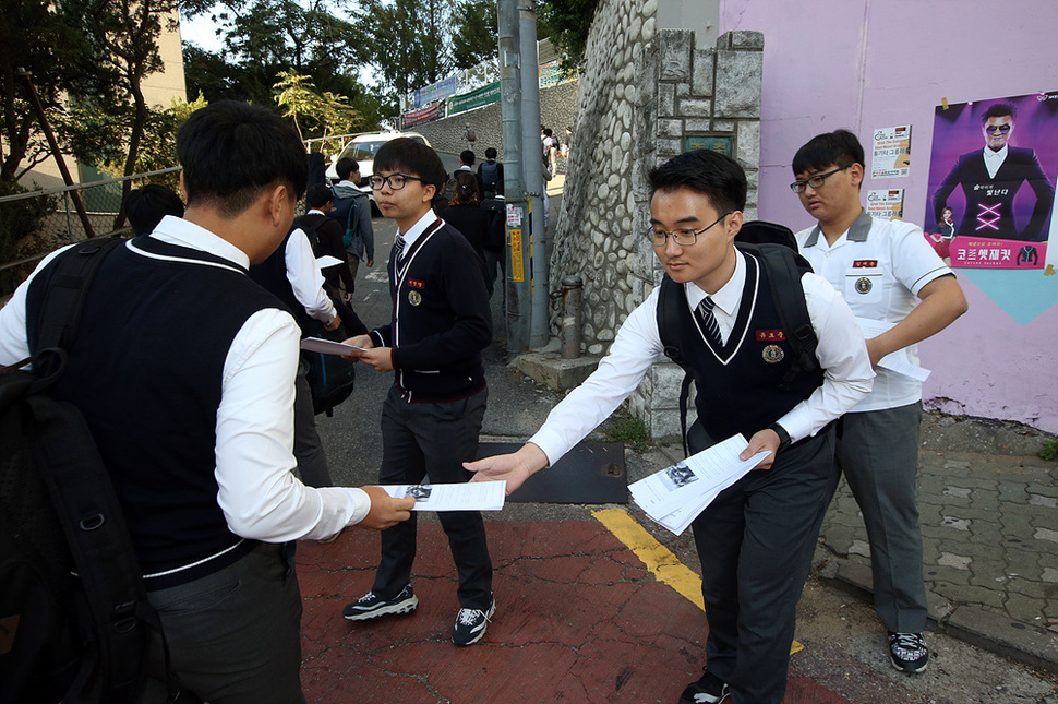 5일 서울 은평구 충암고등학교 앞에서 법·사회학 동아리 학생들이 충암고 급식비리를 다룬 기사를 학생들에게 배포하고 있다. 교육청의 조사 결과 충암중·고교는 납품받은 식재료를 빼돌리려고 종이컵과 수세미 등 소모품을 허위로 과다청구하고, 식용유는 반복해 재사용하는 등의 방법으로 최소 1억5천400만원에 달하는 식자재 비용을 횡령한 것으로 드러났다. 연합뉴스