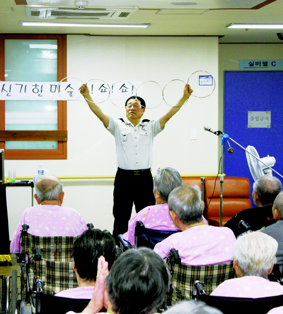 부산 서구 서대신동 ㅅ요양병원에서 경찰이 노인들한테 마술을 선보이고 있다. 부산 서부경찰서는 이를 통해 생활치안 활동을 펼치고 있다. 부산 서부경찰서 제공
