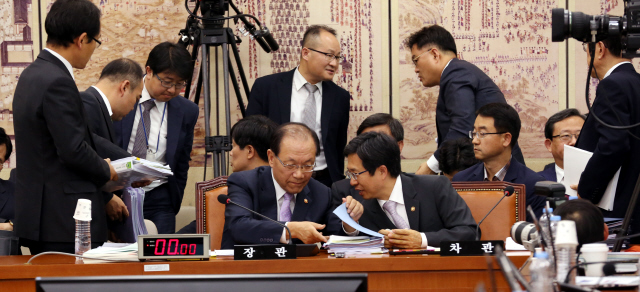 황우여 사회부총리 겸 교육부 장관(앞줄 왼쪽)이 8일 국회에서 열린 국정감사에서 ‘한국사 교과서 국정화’ 논란을 둘러싼 여야 대립으로 정회가 선언된 뒤 김재춘 차관과 이야기하고 있다.  김경호 선임기자 jijae@hani.co.kr