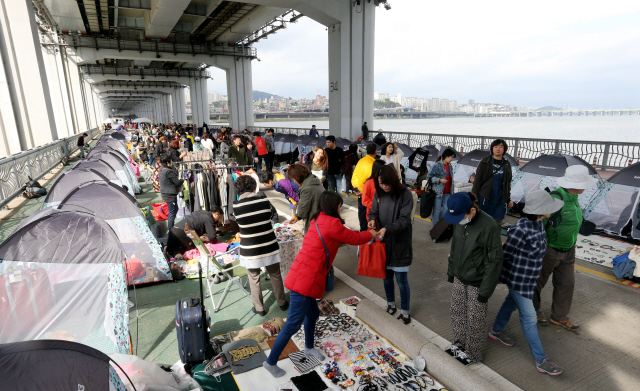 11일 오후 서울 한강 잠수교에서 환경재단 주최로 열린 ‘제2회 잠수교 에코 브릿지 페스티벌’을 찾은 시민들이 에코마켓을 구경하고 있다. 이번 행사는 재창조(에코아트)·재탄생(에코마켓)·재미(에코콘서트)를 주제로 시민이 만들어가는 자원 순환 문화 확산과 지역의 나눔장터 활성화를 위해 열렸다. 김경호 선임기자 jijae@hani.co.kr