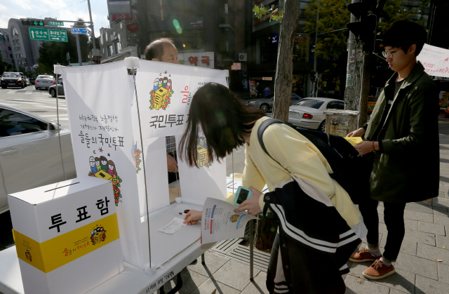 12일 오후 노동시민사회단체들이 정부의 노동시장 구조개편 방안에 대한 의견을 묻고자 서울 마포구 홍익대학교 앞에 설치한 국민투표장에서 시민들이 투표를 하고 있다.   탁기형 선임기자 khtak@hani.co.kr