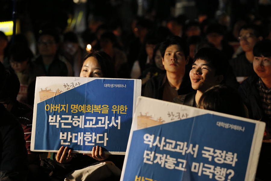 13일 저녁 서울 세종로 정부서울청사 앞에서 열린 ‘한국사 교과서 국정화 강행 규탄 촛불집회’에 참석한 대학생과 시민들이 손팻말과 촛불을 들고 참석자들의 발언을 듣고 있다. 김명진 기자 littleprince@hani.co.kr