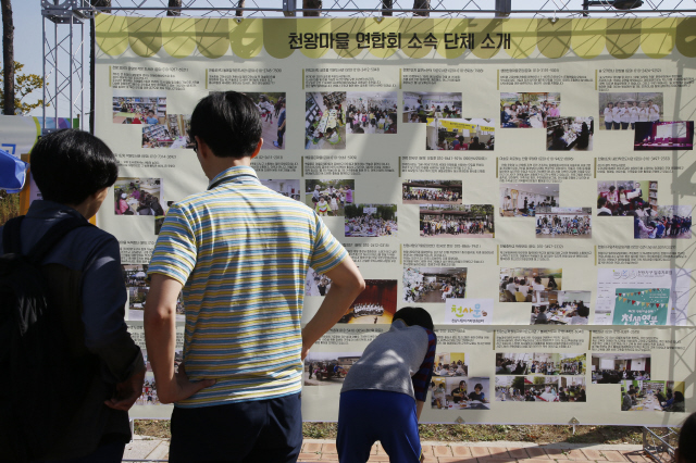 지난 17일 서울 구로구 천왕근린공원에서 ‘천왕 마을축제’가 열렸다. 에스에이치(SH)공사가 지은 천왕지구 8개 아파트 단지 내 소모임 30여곳이 스스로 머리를 맞대 기획하고 준비했다. 캠핑, 여행, 육아 등을 주제로 한 아버지회(‘아빠의 자격’), 천왕동 생협모임, 공동육아와 혁신학교가 관심사인 육층사람들, 엄마들로 구성된 천왕풍물단, 취미와 봉사가 만난 오카리나 동아리, 새마을지도자협의회, 그리고 단지 내 주부 120여명으로 구성된 아파트 작은도서관 활동가 모임도 그 가운데 하나다. 작은도서관 모임은 이번 축제에서 독서체험 부스를 열었다.  이정아 기자 <A href="mailto:leej@hani.co.kr">leej@hani.co.kr</A>