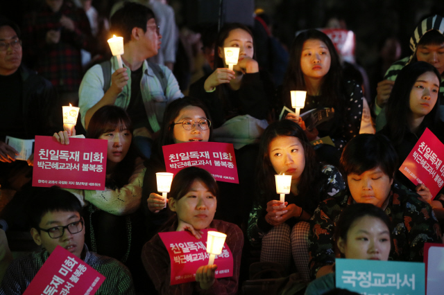 손에 촛불을 든 시민과 청소년들이 17일 저녁 서울 중구 태평로1가 서울파이낸스센터 앞에서 열린 ‘한국사 교과서 국정화 막는 국민 촛불대회’에서 정부의 일방 강행을 규탄하는 자유 발언을 듣고 있다.  이정아 기자 leej@hani.co.kr