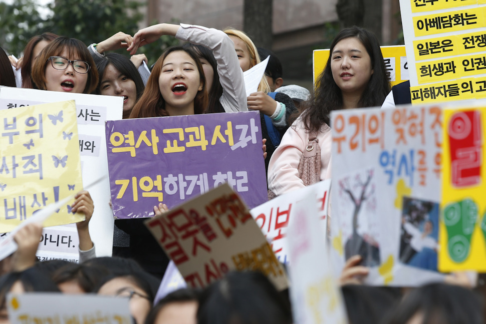 일본군 위안부 문제 해결을 위한 정기 수요시위(1201차)가 열린 21일 낮 서울 종로구 중학동 일본대사관 앞에서 한 참가자가 ‘역사 교과서가 기억하게 하라’고 쓴 손팻말을 흔들며 윤미향 한국정신대대책협의회 상임대표의 선창에 따라 역사교과서 국정화 반대를 외치고 있다.  이정아 기자 leej@hani.co.kr