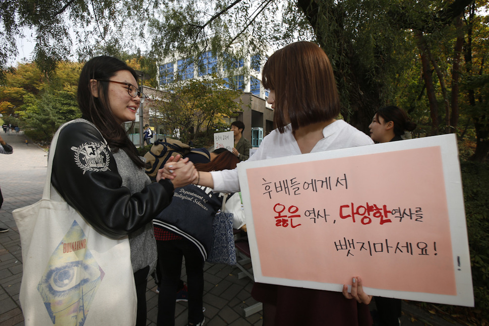 서울대 평화나비와 한국사 교과서 국정화 저지 서울대 네트워크 학생들이 22일 오전 서울 관악구 신림동 교내 자하연 광장에서 한국사 교과서 국정화 반대 서명운동을 벌이고 있다. 서명운동을 벌이고 있는 한 학생에게 친구가 다가와 악수를 청하고 있다. 이정아 기자 leej@hani.co.kr