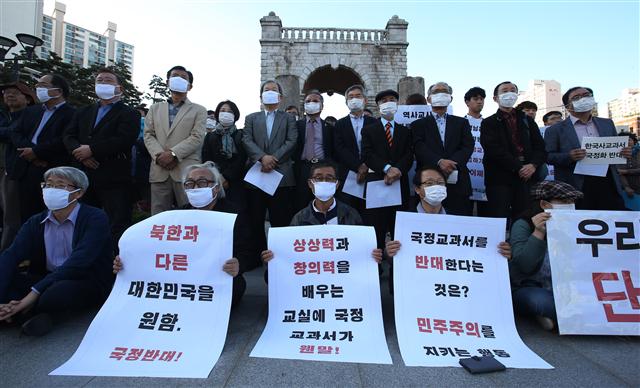 안병욱 가톨릭대 교수(사진 뒤쪽 왼쪽 일곱째)를 비롯한 원로 역사학자들이 지난 24일 오후 서울 서대문독립공원에서 역사 연구자와 교사들과 함께 마스크를 쓰고 침묵으로 ‘역사 교과서 국정화’에 반대하고 있다. 연합뉴스