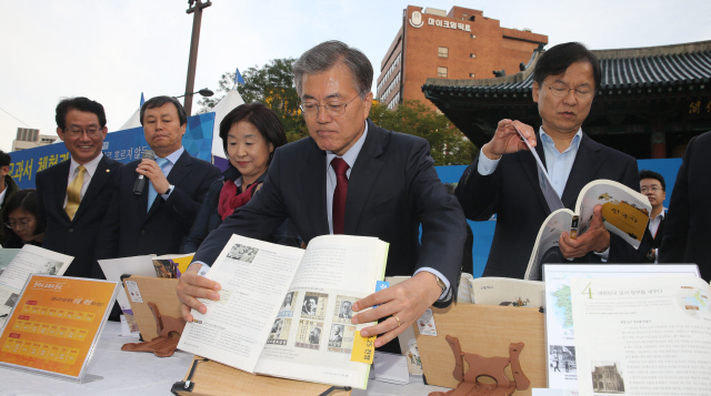 문재인 새정치민주연합 대표(오른쪽 둘째)와 심상정 정의당 대표(오른쪽 셋째), 천정배 무소속 의원(맨 오른쪽) 등이 25일 오후 서울 종로1가 보신각 공원에서 열린 한국사 교과서 체험관 개막식에서 전시중인 한국사 교과서들을 살펴보고 있다. 김경호 선임기자 jijae@hani.co.kr