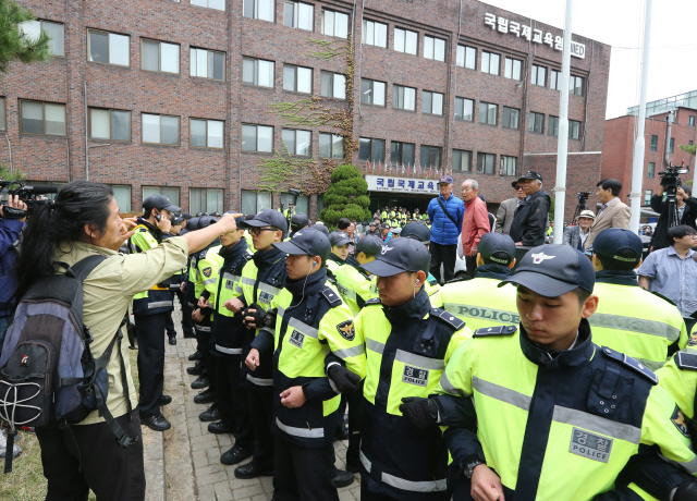 역사 교과서 국정화를 위해 교육부가 비밀리에 운영해온 태스크포스(TF)팀이 머물고 있는 서울 종로구 동숭동 국립국제교육원의 정부초청 외국인장학생 회관 옆 본관 앞에서 26일 오후 어버이연합 등 보수단체 회원들이 국정화 찬성 집회를 열고 있다. 한 시민이 폴리스라인 너머로 이들을 향해 고함을 치고 있다.  김태형 기자 xogud555@hani.co.kr