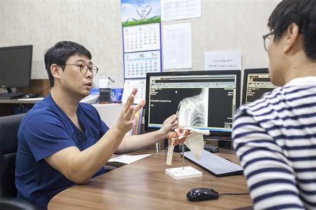 어깨에 극심한 통증이 나타난 환자가 방사선 촬영을 한 뒤 석회성 힘줄염으로 진단돼 관련 전문의의 설명을 듣고 있다.  바른세상병원 제공