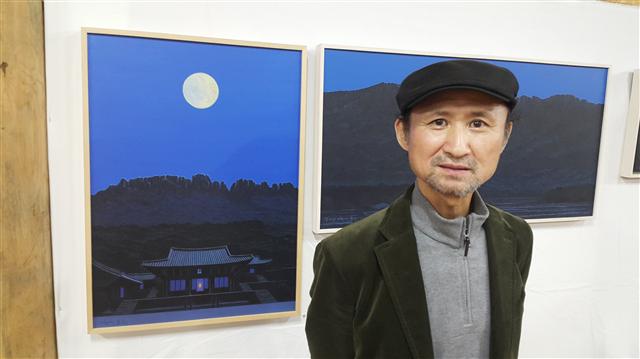 달밤의 미황사 대웅전을 그린 신작 앞에 선 이종구 작가.  
