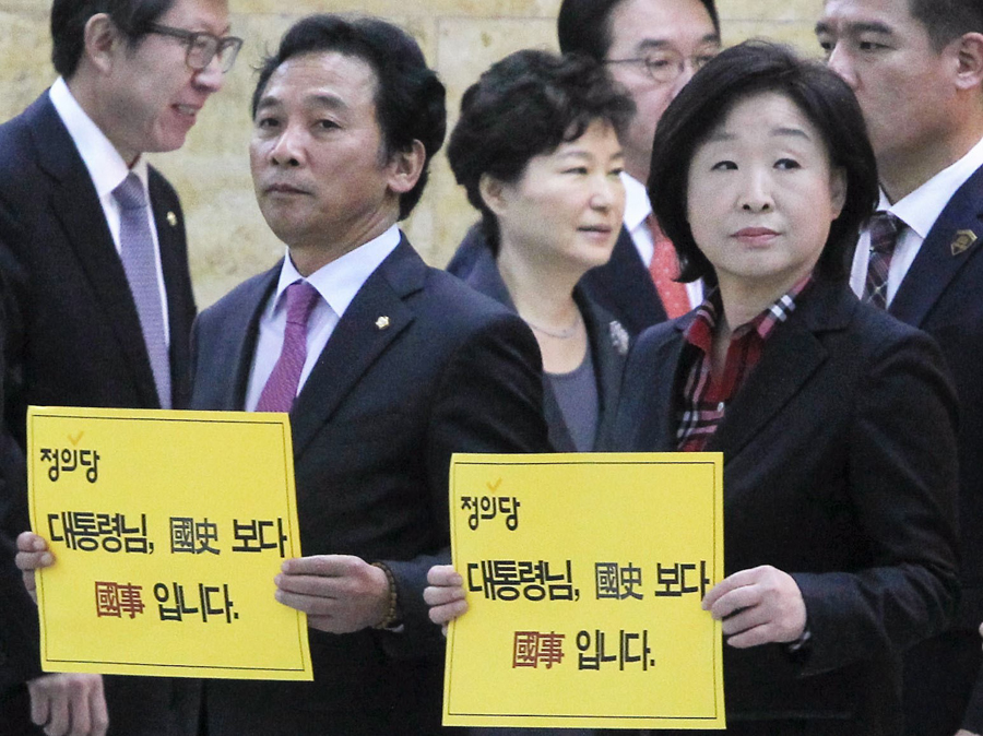 박근혜 대통령이 내년도 예산안 시정연설을 위해 27일 서울 여의도 국회 본회의장으로 들어서고 있는 가운데 정의당 심상정 대표를 비롯한 의원들이 ‘국정교과서 반대‘ 피켓시위를 하고 있다. 공동취재사진