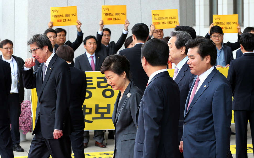 박근혜 대통령이 27일 오전 시정연설을 끝내고 김무성 새누리당 대표 등 지도부의 안내를 받은며 국회를 나서고 있다. 박대통령 뒤로 정의당 의원들이 국정화 반대 피켓시위를 벌이고 있다. 김경호 선임기자 jijae@hani.co.kr