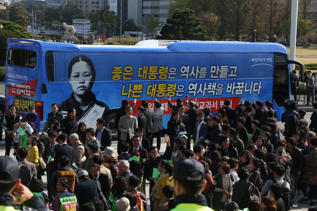 새정치민주연합 당직자들이 28일 오후 국회 의사당 앞에서 ‘국정교과서 반대 홍보 버스 출정식’을 마친 뒤, 문재인 대표 등 지도부를 태운 버스가 부천을 향해 출발하자 손을 흔들고 있다.  이정우 선임기자 woo@hani.co.kr