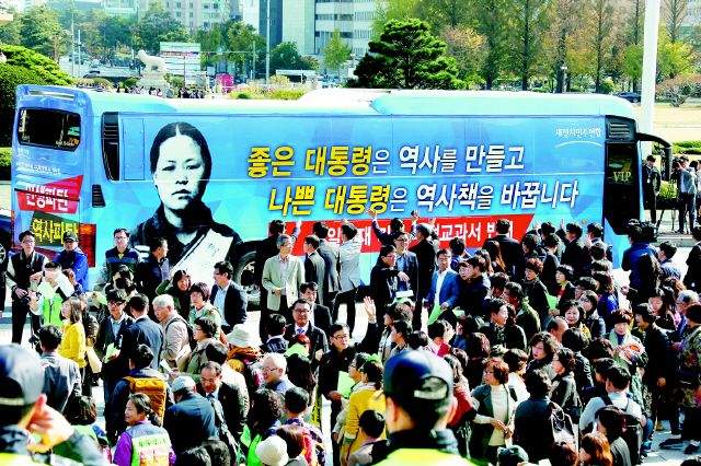 새정치민주연합 당직자들이 28일 국회 의사당 앞에서 ‘국정교과서 반대 홍보 버스 출정식’을 마친 뒤 문재인 대표 등 지도부를 태운 버스가 경기도 부천을 향해 출발하자 손을 흔들고 있다. 이정우 선임기자 woo@hani.co.kr