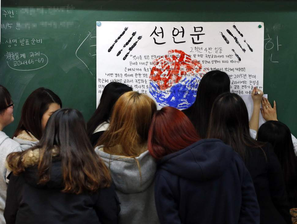 정부가 교과서 국정화 확정 고시를 발표한 3일 오후 서울 강동구 선사고등학교 2학년 4반 학생들이 제86회 ‘학생의 날’ 기념행사로 열린 ‘학급별 학생선언문 쓰기 행사’에서 손도장을 찍어 태극기를 그리고, 그 위에 ‘역사 교과서 국정화 문제’에 대한 자신들의 생각을 담은 선언문을 쓰고 있다. 이정아 기자 leej@hani.co.kr