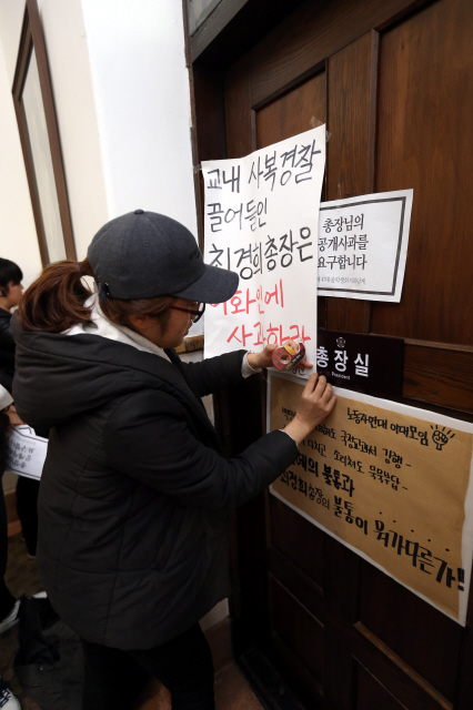 5일 오후 이화여대 학생들이 서울 서대문구 이화여대 본관 총장실 출입문에 지난달 29일 전국여성대회에 박근혜 대통령이 참석할 때 일어난 학내 사복 경찰 진입과 폭력 행사에 대한 최경희 총장의 사과와 해명을 요구하는 손팻말을 붙이고 있다. 학생들은 이날 총장을 만나 사태에 대한 해명과 사과를 요구하려 했으나, 최 총장이 출장 중이라 직접 만나지 못했다.  김태형 기자 xogud555@hani.co.kr