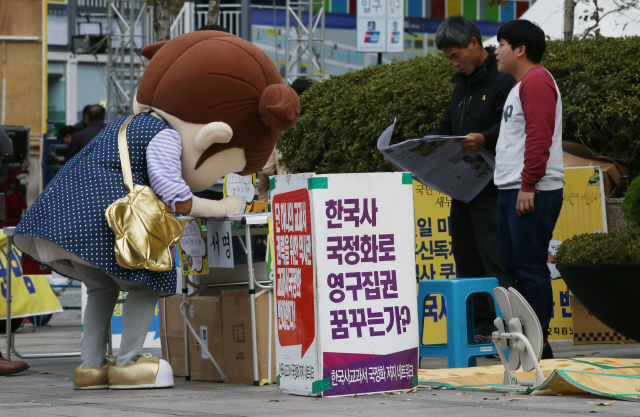 6일 오후 서울 청계광장에서 마스코트 인형 복장을 한 시민이 역사교과서 국정화 반대 서명을 하고 있다. 신소영 기자 viator@hani.co.kr