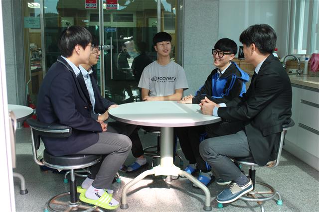 지난 5일 교복을 입은 삼천포고 김성곤 교사(맨 오른쪽)가 학생들과 이야기를 나누고 있다. 학교는 중앙현관을 리모델링해 카페 겸 상담실로 꾸몄다. 1, 2학년 교무실과 연결돼 학생들이 자유롭게 교사와 진로·진학은 물론 생활 상담을 할 수 있다.  최화진 기자