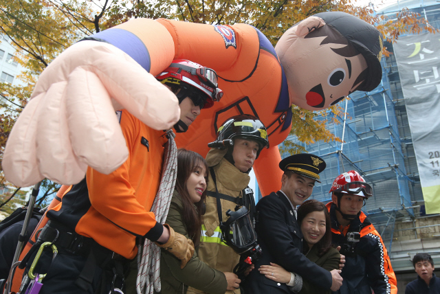 제53주년 소방의 날인 9일 오전 서울 중구 명동길 명동예술극장 앞에서 소방관들이 시민과 관광객들에게 프리허그를 해주고 있다. 불특정 다수를 안아주는 프리허그는 포옹을 통해 정신적 상처를 치유하고 평화로운 사회를 이루려는 행위다. 신소영 기자 viator@hani.co.kr