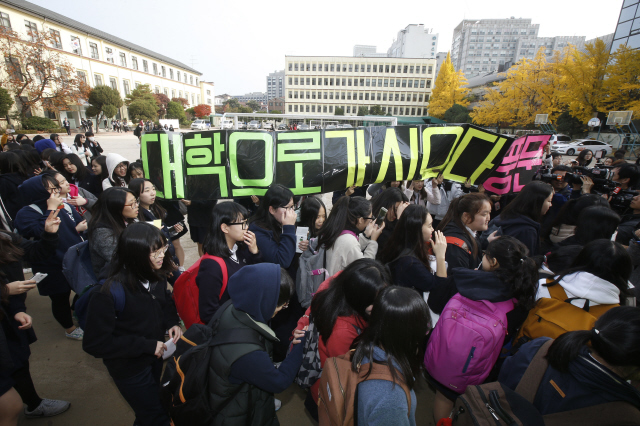 서울 풍문여고 3학년 학생들이 11일 오전 서울 종로구 안국동 교정에서 후배들과 교사들의 응원을 받으며 고사장 확인을 위해 학교를 나서고 있다. 올해 대학수학능력시험은 지난해보다 9434명이 줄어든 63만1178명이 응시원서를 내, 전국 85개 시험지구 1212개 시험장에서 치러진다. 응시생들은 오전 8시10분까지 입실을 마쳐야 한다.  이정아 기자 leej@hani.co.kr