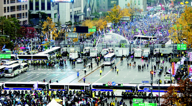 14일 오후 서울 광화문사거리에서 경찰이 차벽 너머에 모여 있는 민중총궐기대회 참가자들을 향해 물대포를 쏘고 있다.  김성광 기자 flysg2@hani.co.kr