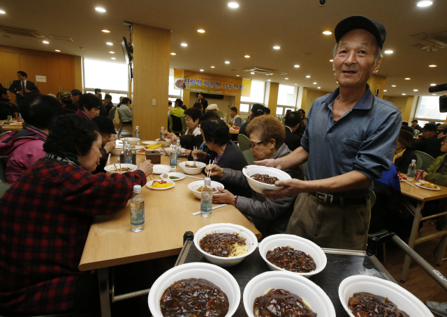 쪽방 주민 고순덕(오른쪽)씨가 19일 오전 서울 종로구 돈의동 초동교회에서 열린 ‘사랑의 짜장면 나눔잔치’에 재능기부자로 참여해 음식을 나눠주고 있다. 이날 행사는 돈의동 쪽방촌에서 지킴이 활동을 하고 있는 오아무개씨와 기초생활수급자인 이아무개씨가 이웃의 도움에 보답하겠다며 어렵게 모은 130만원을 기탁한 것이 기부 나눔으로 이어져 성사됐다. 이정아 기자 <A href="mailto:leej@hani.co.kr">leej@hani.co.kr</A>