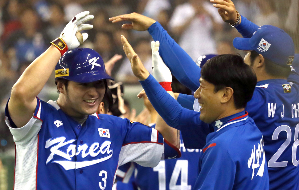 21일 오후 일본 도쿄돔 구장에서 열린 2015 세계야구소프트볼연맹(WBSC) 프리미어12 대회 결승전 대한민국과 미국의 경기. 4회초 2사 주자 2, 3루 때 대한민국 박병호가 좌월 3점 홈런을 친 뒤 더그 아웃에 들어와 팀 동료들의 축하를 받고 있다. 2015.11.21(도쿄=연합뉴스)