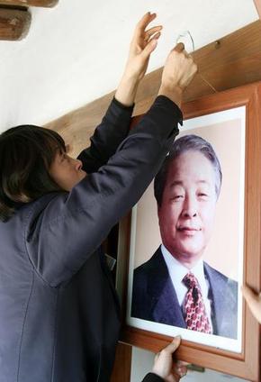 22일 오전 경남 거제시 장목면 대계마을 김영삼 전 대통령 생가에 걸려 있는 김 전 대통령 사진을 관계자들이 내리고 있다. 이 사진은 이 지역 분향소에 영정으로 걸렸다. 거제/연합뉴스