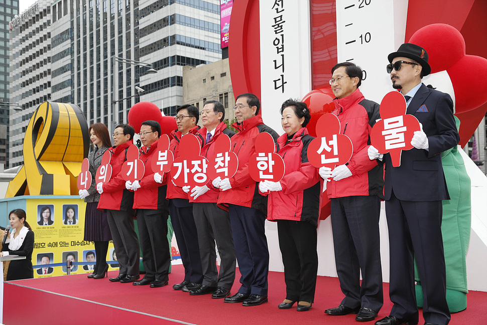 23일 오후 서울 광화문 광장 이순신 동산 앞에서 열린 ‘사랑의 온도탑’ 제막행사에서 가수 박상민 씨 등 참석자들이 기부 참여를 촉구하는 손팻말을 들고 있다. 김봉규 선임기자 bong9@hani.co.kr