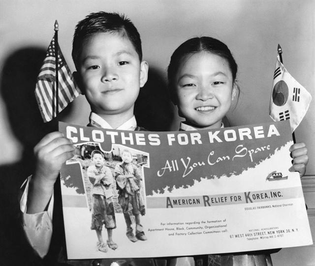1953년 봄 미국 구호단체연합체(ARK)가 한국전쟁 고아와 구호민 옷 수집 캠페인을 위해 만든 포스터를 들고 있는 어린이들. <뉴욕 타임스> 53년 3월17일치에 실린 사진이다. 윤정란 제공