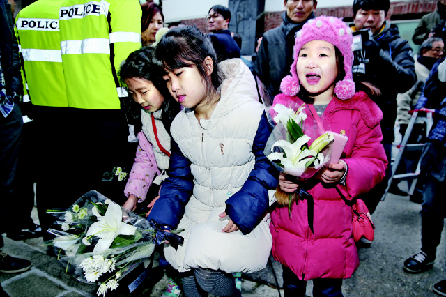 김영삼 전 대통령의 영정이 26일 오후 서울 동작구 상도동 사저를 들렀다 떠난 뒤 동네 어린이들이 자택 앞에 헌화하고 있다. 김태형 기자 <A href="mailto:xogud555@hani.co.kr">xogud555@hani.co.kr</A>