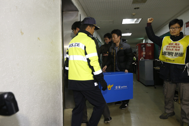 서울남대문경찰서 소속 경찰관들이 27일 낮 경기 수원시 팔달구 전국민주노동조합총연맹 경기본부를 압수수색해 확보한 물품을 옮기는 동안 한 조합원이 ‘노조 탄압을 중단하라’며 경찰을 규탄하고 있다. 경찰은 지난 5월1일 노동절 집회 당시 서울 종로구 안국동 네거리 앞에서 밧줄로 경찰 기동대 버스를 부순 경기본부 소속 간부 2명의 혐의를 입증하기 위한 증거물을 확보하기 위해 이날 압수수색을 실시했다고 밝혔다. 이정아 기자 leej@hani.co.kr