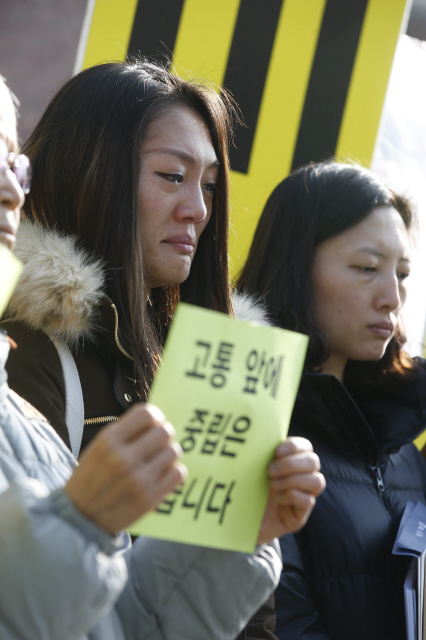 지난달 14일 민중총궐기대회에 참가했다가 경찰의 물대포에 맞아 중태에 빠진 농민 백남기씨의 딸 백민주화씨가 1일 오전 종로구 청운효자동주민센터 앞에서 열린 ‘교황께 보내는 공개서한 전달식’에 참석해 아버지가 살아온 길을 소개하는 참가자의 발언을 들으며 눈물을 흘리고 있다. 백씨 곁에 선 한 참가자가 교황이 방한 당시 세월호 유족을 만나 “고통 앞에 중립을 지킬 수 없다”고 한 발언을 쓴 손팻말 들고 있다.   이정아 기자 leej@hani.co.kr