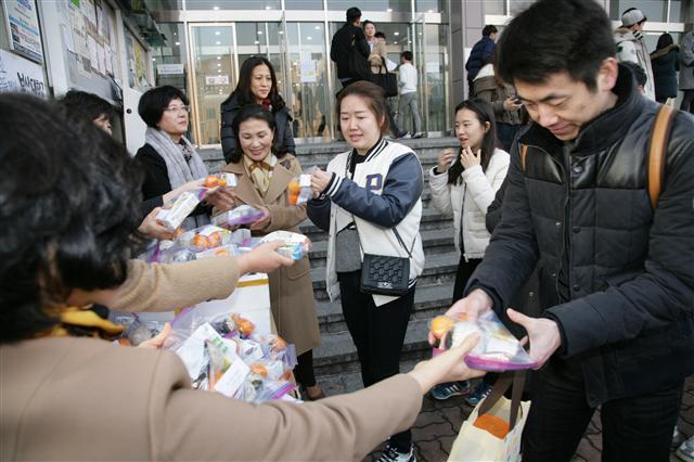 부산대 여교수회 소속 교수들이 부산대 제2도서관(옛 중앙도서관) 앞에서 손수 만든 주먹밥을 학생들한테 나눠주고 있다.  부산대 제공