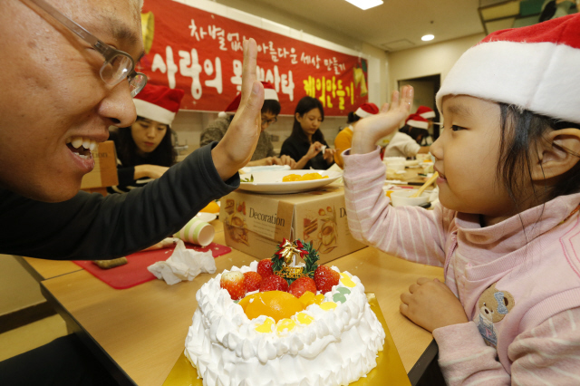 서울 구로구 홈플러스 신도림점 문화센터에서 20일 오후 열린 ‘차별 없는 아름다운 세상 만들기, 사랑의 몰래산타 케이크 만들기’ 행사에서 신도림 주민인 인신우(42)씨와 딸 수정(5)양이 딸기와 크리스마스 장식물로 꾸민 케이크를 만든 뒤 손바닥을 마주치고 있다. ‘신도림커뮤니티’를 통해 참여한 인근 주민 30여명은 이날 20여개의 케이크를 만들어 주위의 어려운 가정에 전달할 예정이다.  김봉규 선임기자 bong9@hani.co.kr