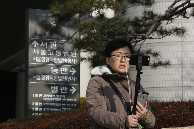 재판 중계하는 댓글 피해자 ‘망치부인’ 닉네임 ‘좌익효수’로 호남·여성 등을 비하한 글을 반복적으로 인터넷에 올린 국가정보원 직원 유아무개씨에 대해 국가정보원법 위반 혐의로 첫번째 공판이 열린 22일 오전 서울 서초동 서울중앙지법 앞에서 인터넷 시사방송 진행자인 ‘망치부인’ 이경선씨가 자신의 입장을 스마트폰으로 중계방송하고 있다.  이정아 기자 leej@hani.co.kr