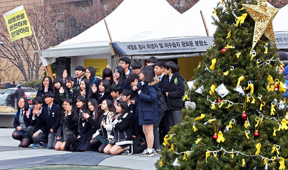 성탄절을 하루 앞둔 24일 오후 서울 광화문 세월호 분향소를 찾은 문창중학교 3학년 2반 학생들이 분향을 마친 뒤 세월호 참사를 잊지말자며 노랑리본을 손에 들고 기념촬영을 하고 있다. 이정용 선임기자 lee312@hani.co.kr