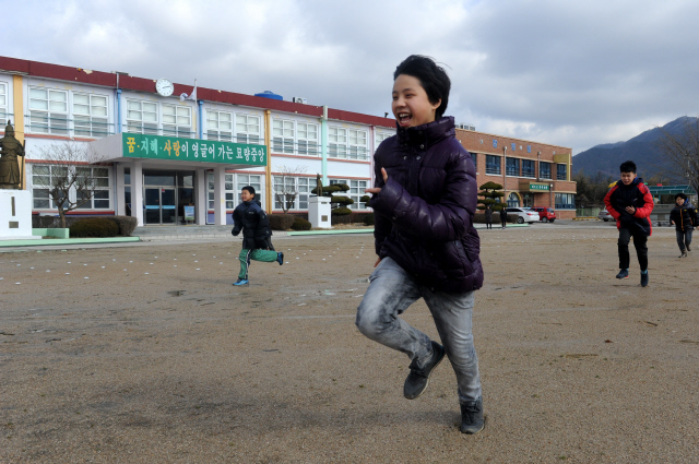 묘량중앙초등학교 운동장에서 달리는 소년 네 사람.