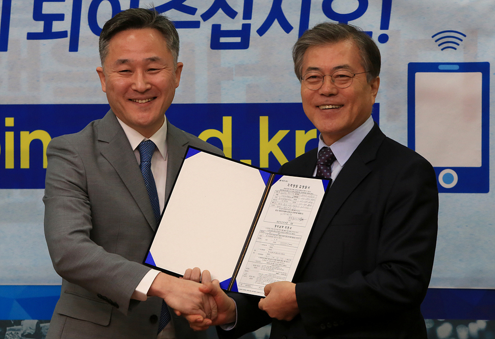 표창원 전 경찰대 교수가 27일 오전 국회 새정치민주연합 대표위원실에서 열린 입당 기자회견에서 문재인 대표로부터 지역당원입당원서를 받으며 악수하고 있다. 탁기형 선임기자 khtak@hani.co.kr