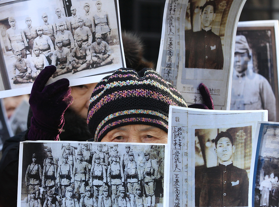 아시아태평양전쟁희생자 한국유족회가 28일 한일 외교장관 회담이 열리는 서울 종로구 도렴동 외교부 청사 후문 앞에서 일제징용 피해자 손해배상 책임 등을 한일 정부에 요구하며 피해자들의 사진을 들고 있다. AP 연합뉴스